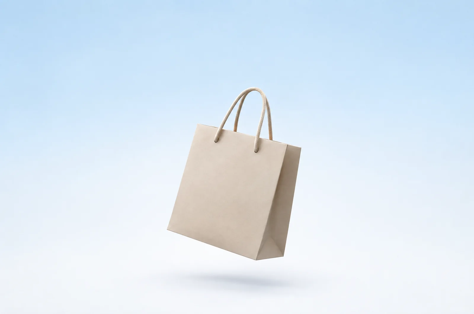 A glass shopping bag on a pale blue surface